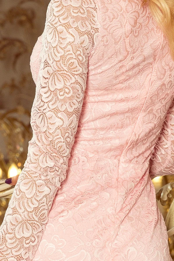 Gaiši rozā mežģīņu kleita ar garām piedurknēm, kas piešķir elegantu un romantisku izskatu. Kleita ir cieši pieguļoša, izceļot sievišķīgās formas un detaļas.