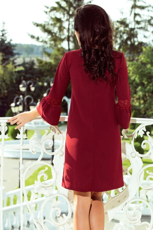 Eleganta bordo krāsas kleita ar mežģīņu detaļām uz piedurknēm piešķir sievišķīgu šarmu. Taisns griezums un garums līdz ceļiem padara to piemērotu gan ikdienai, gan svinīgiem pasākumiem.