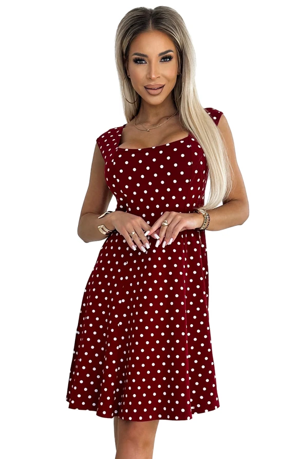 Sieviešu kleita sarkanā krāsā ar baltu punktu rakstu, kas piešķir tai retro šarmu. Kleitai ir elegants piegriezums ar īsām piedurknēm un viegli izplestu svārku daļu.