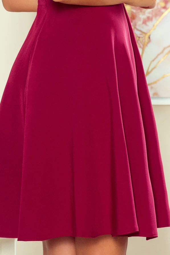 Sieviešu kleita koši sarkanā krāsā ar elegantu, viegli plandošu svārku daļu. Audums ir gluds un spīdīgs, piešķirot kleitai izsmalcinātu izskatu.