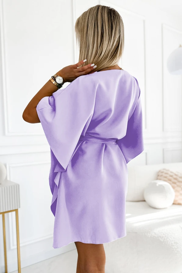 Sieviešu kleita ar brīvi krītošiem, platām piedurknēm un jostu, kas akcentē vidukli. Kleita ir gaiši violetā krāsā, piešķirot tai elegantu un modernu izskatu.
