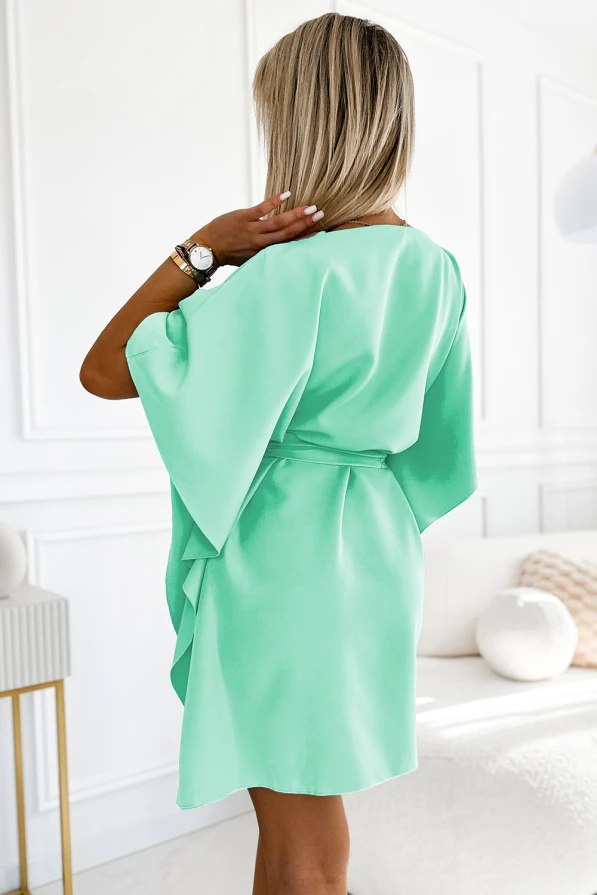 Sieviešu kleita maigā piparmētru krāsā ar elegantu jostu, kas izceļ vidukli. Kleitai ir brīvi krītoši, plati piedurknes, kas piešķir tai vieglumu un eleganci.