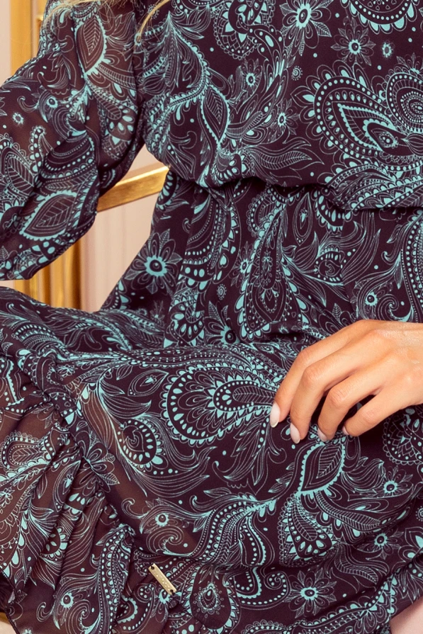 Gaisīga šifona kleita ar sarežģītu ziedu un paisley rakstu, kas apvieno tumšus un gaiši zilus toņus. Kleita ir eleganta un piemērota gan ikdienas, gan svētku pasākumiem.