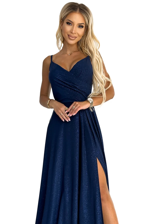 Eleganta tumši zila maxi kleita ar spīdīgu audumu un platu šķēlumu sānos. Kleitai ir plānas lencītes un pieguļošs augšdaļas dizains, kas izceļ sievišķību.