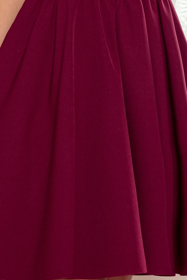 Sieviešu kleita tumši sarkanā krāsā ar elegantu krokojumu un vieglu audumu. Dizains ir vienkāršs, bet izsmalcināts, piemērots dažādiem svinīgiem pasākumiem.