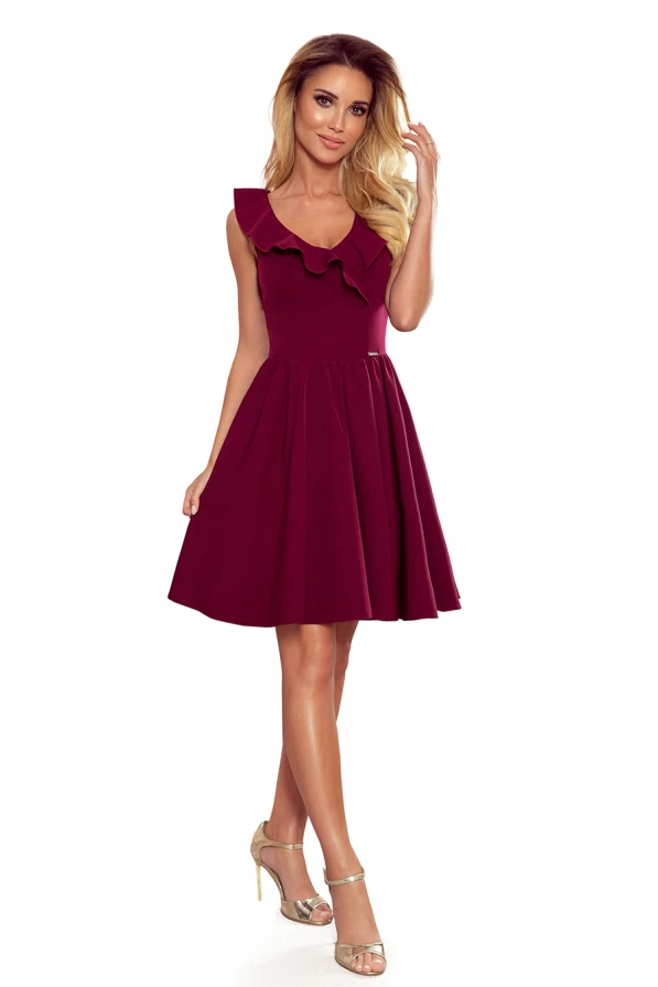 Sieviešu kleita bordo krāsā ar elegantu volānu pie kakla izgriezuma. Kleitai ir bezpiedurkņu dizains un viegli izplests svārku daļa, kas piešķir tai sievišķīgu šarmu.