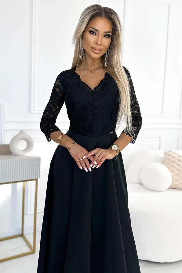 Eleganta melna kleita ar trīs ceturtdaļu garuma mežģīņu piedurknēm un V veida izgriezumu. Kleita ir piemērota svinīgiem pasākumiem, piešķirot valkātājai izsmalcinātu un stilīgu izskatu.