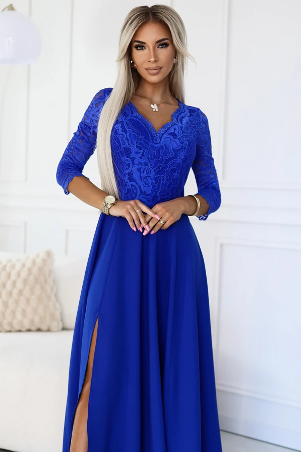 Eleganta, gara kleita koši zilā krāsā ar mežģīņu augšdaļu un trīs ceturtdaļu piedurknēm. Kleitai ir sievišķīgs šķēlums, kas piešķir tai izsmalcinātu un modernu izskatu.