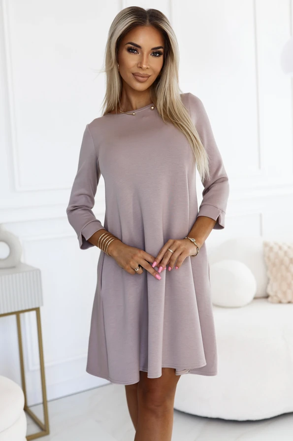 Sieviešu kleita ar trīs ceturtdaļu piedurknēm un trapezveida siluetu, kas izgatavota no maiga, gaiši pelēka auduma. Kleita ir eleganta un piemērota gan ikdienas, gan svētku pasākumiem.